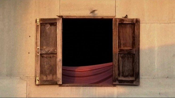 Two wooden windows open into a dark room